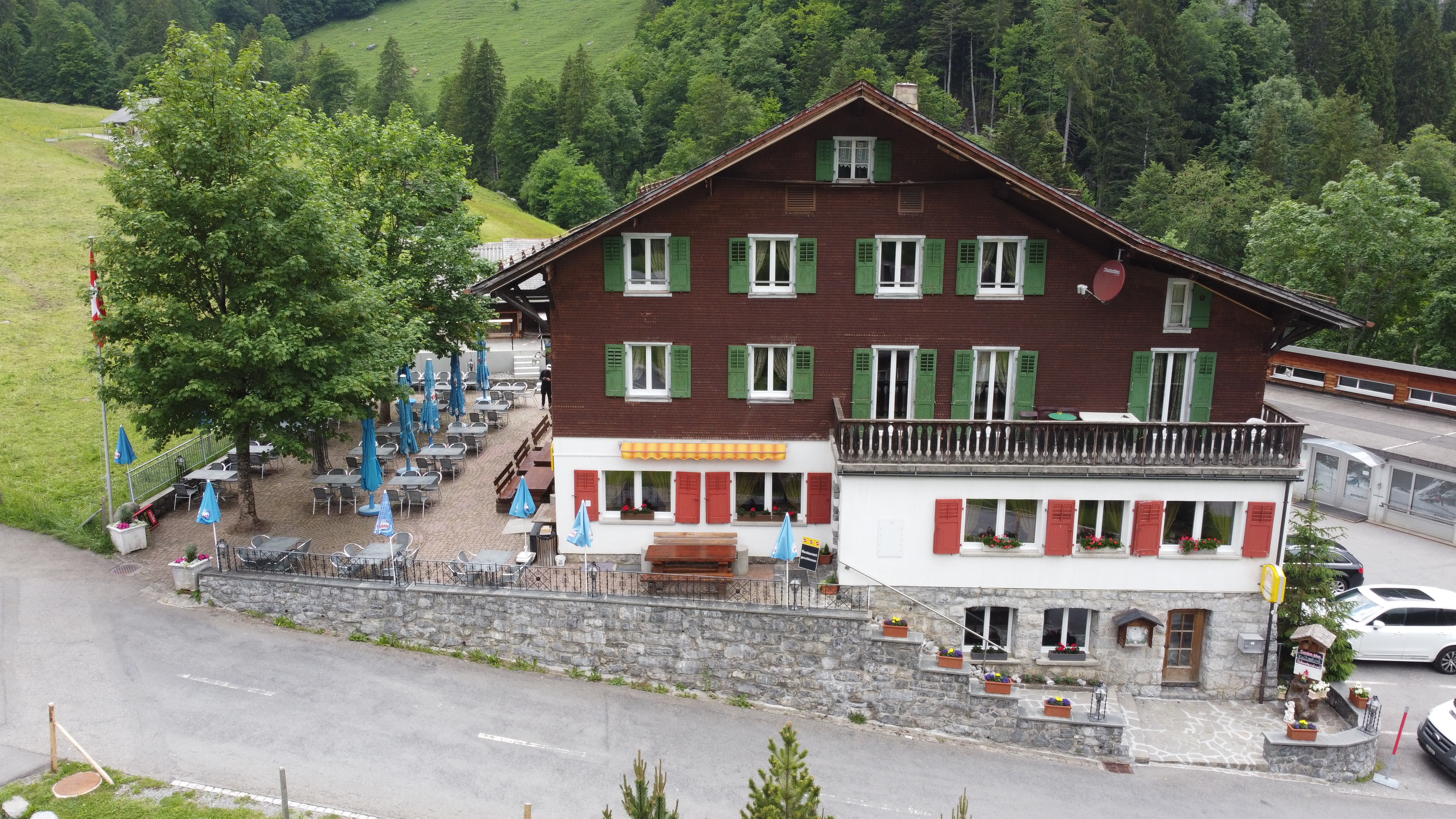 Frontansicht des Waldhauses Stöckalp mit grünen Fensterläden